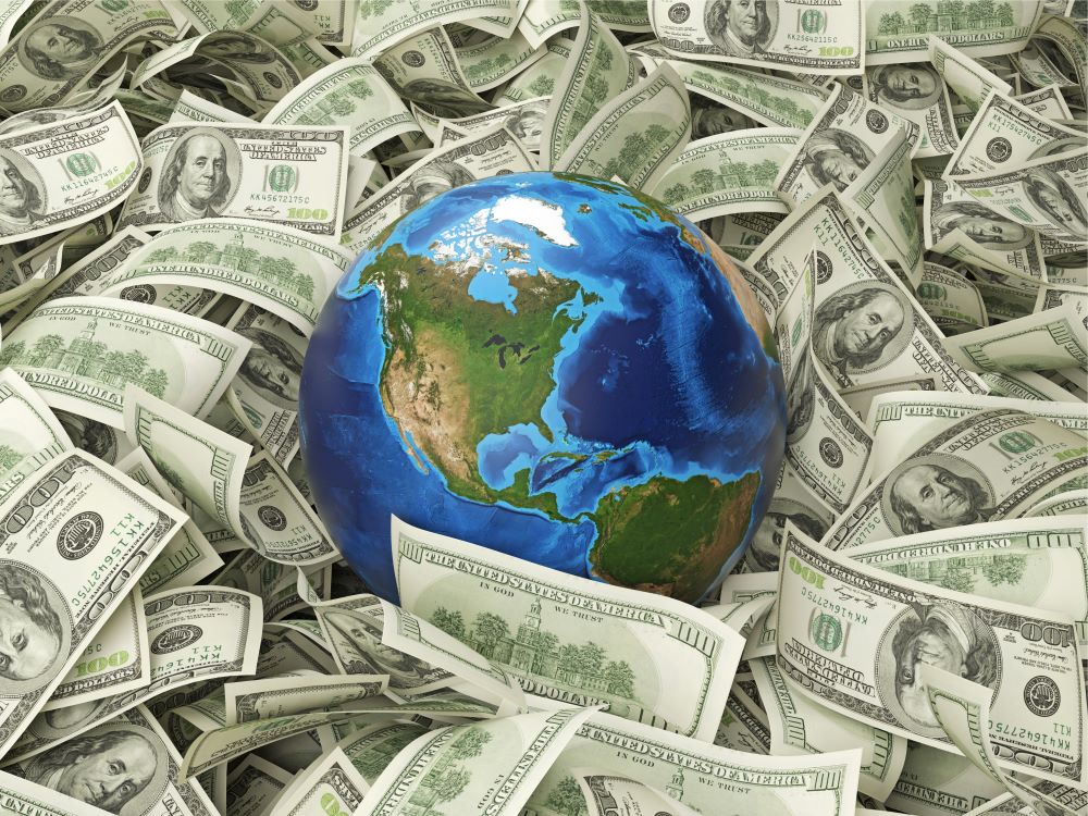 Image of a globe laying amongst dollar notes